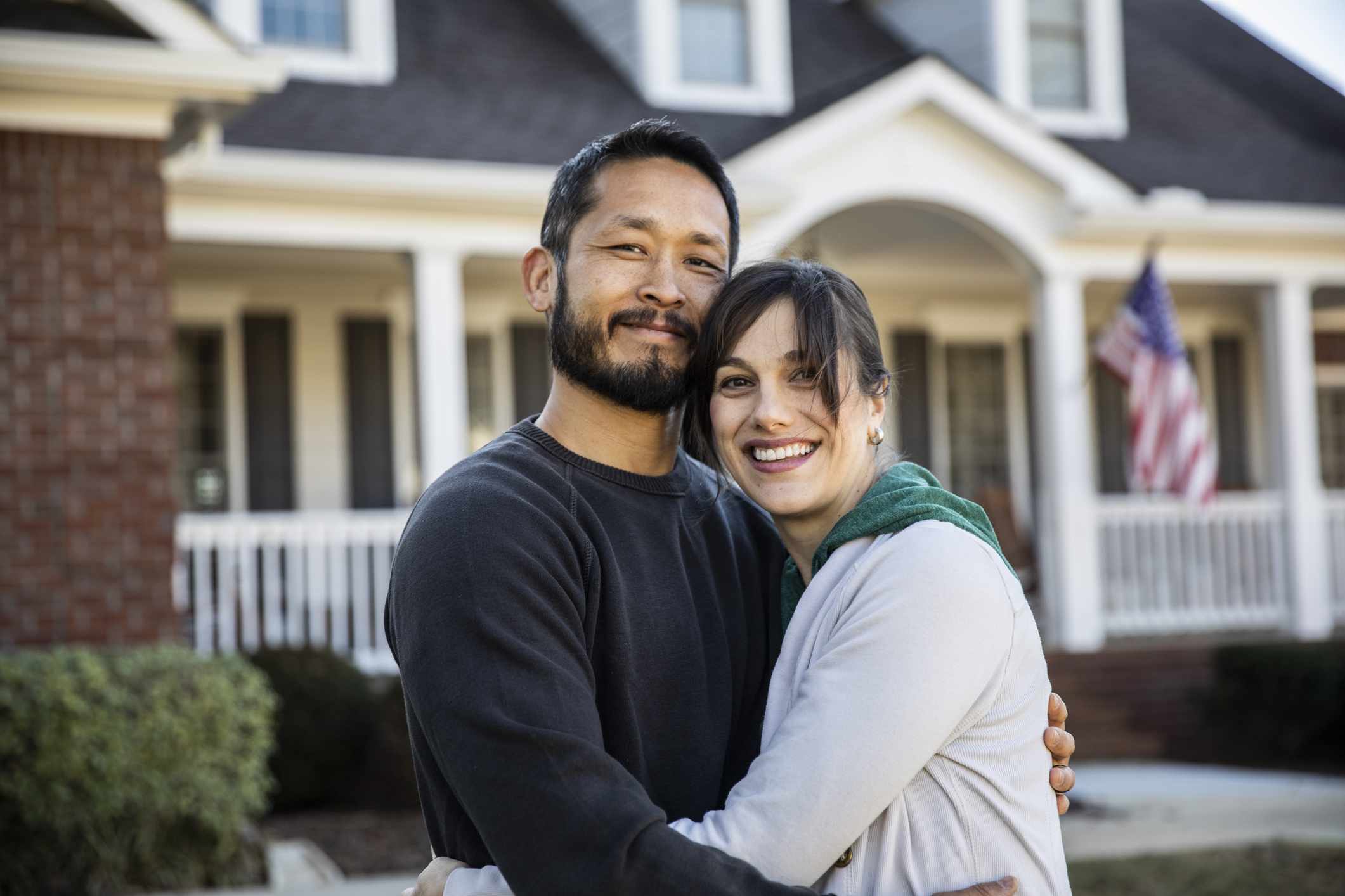 couple embracing in front of a house