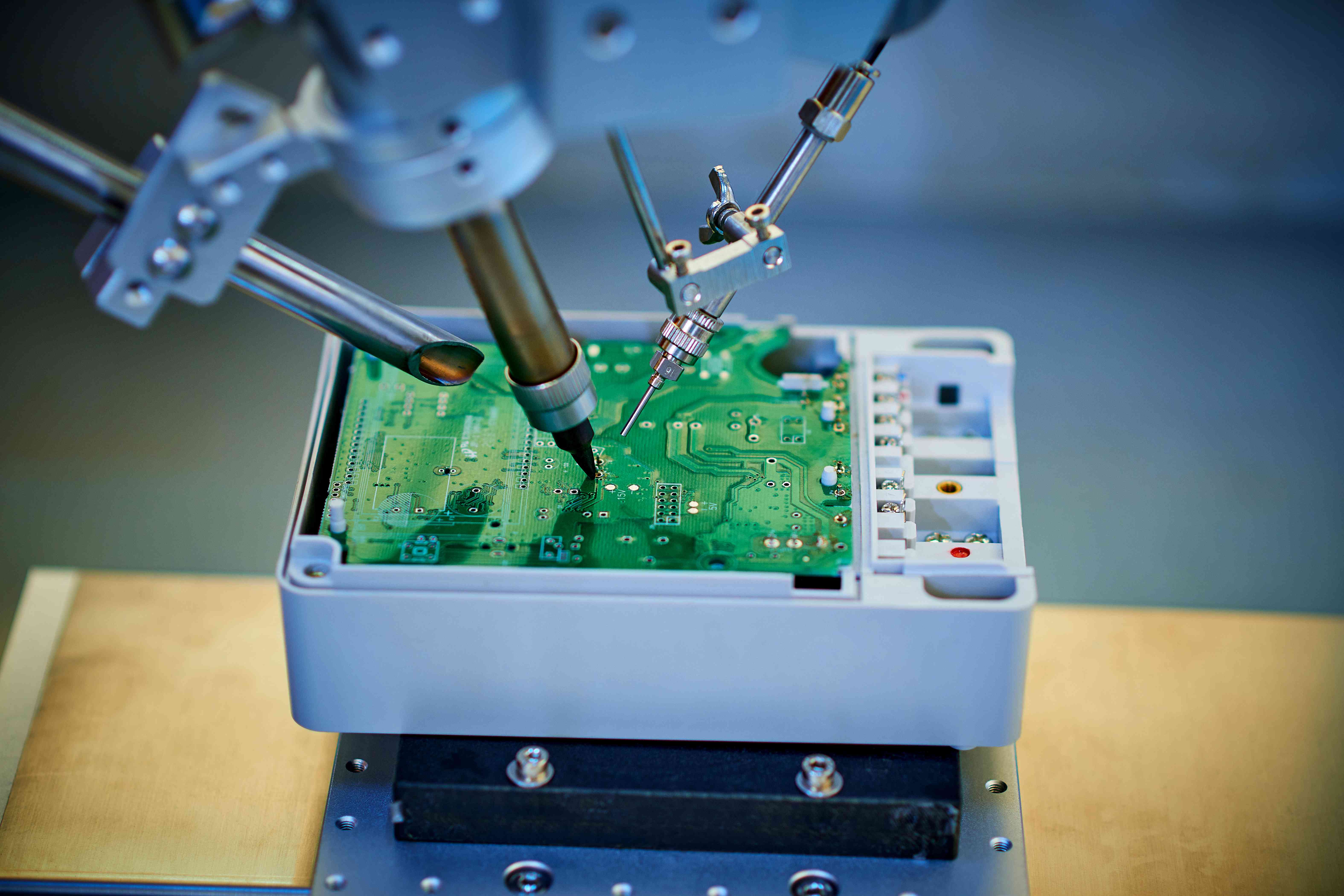 Robotic arm welding and installing component onto semiconductor circuit board on workbench