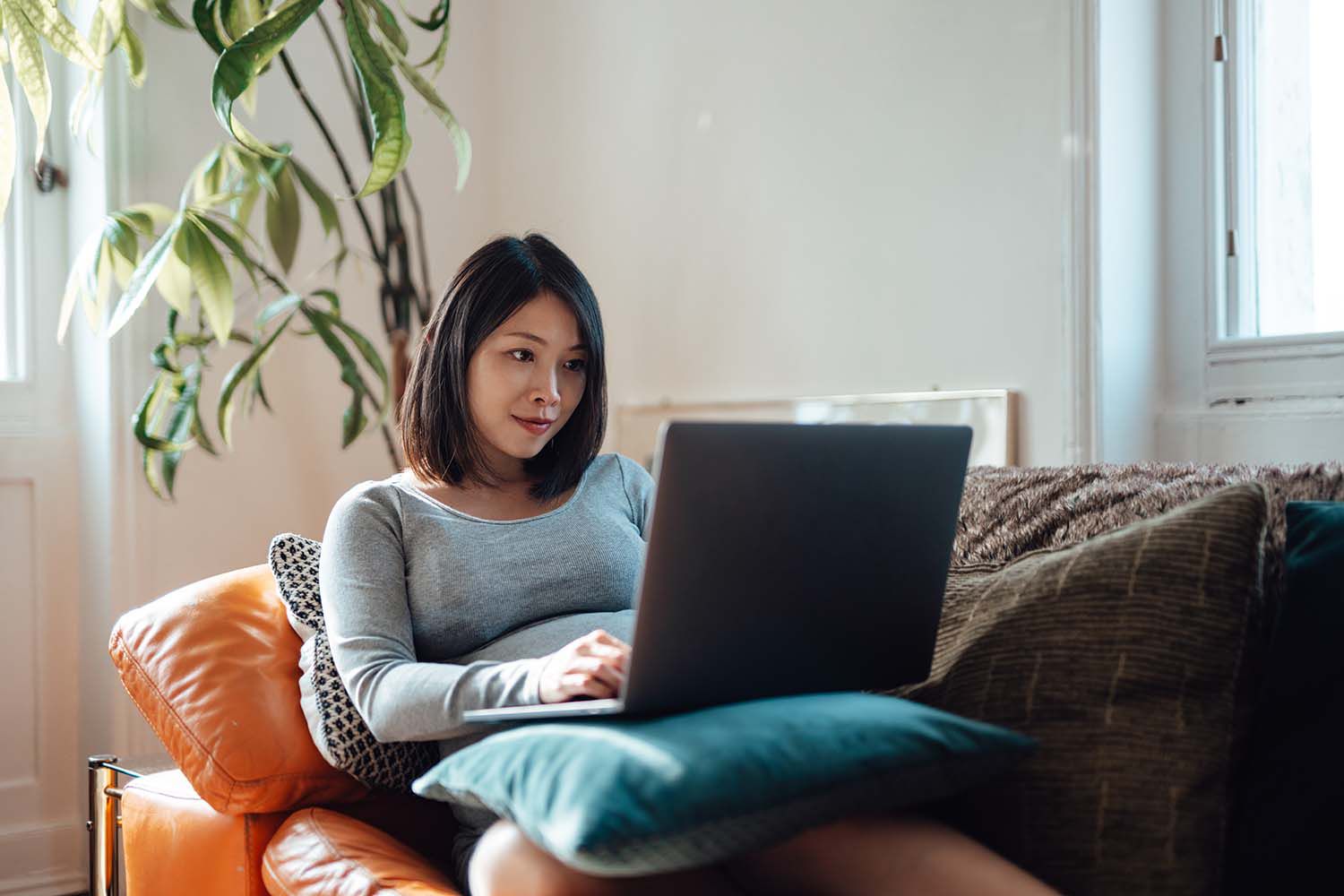 Businesswoman at home office, working with laptop on sofa
